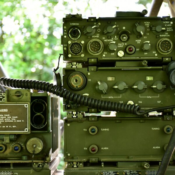 a couple of military radio equipment sitting on top of a wooden table