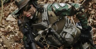 man holding rifle on ground